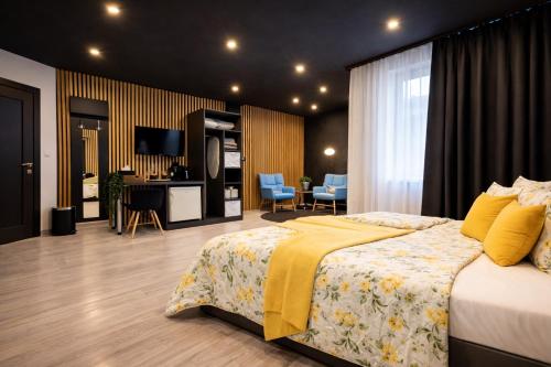 a bedroom with a bed with a yellow blanket on it at Vila GARUFA Wellness & Spa in Vysoké Tatry