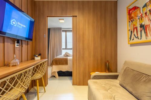 a living room with a couch and a flat screen tv at Premium Lago Centro de Atividade do Lago Norte - Torre 2 -316 - Studio Neruda - 12 min da Esplanada - O mais bem avaliado na plataforma - By Hospede Fácil in Brasília