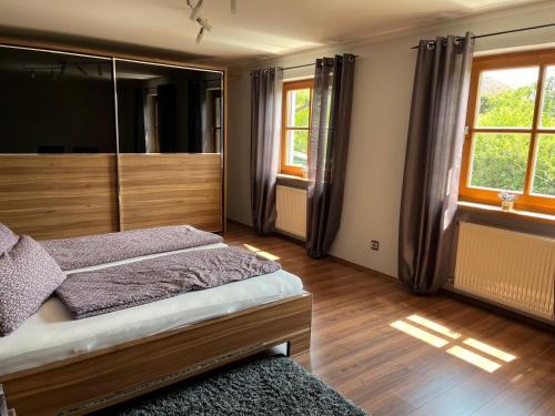 a bedroom with a bed and two windows at Ferienwohnung Sonnenblick in Grafenwiesen