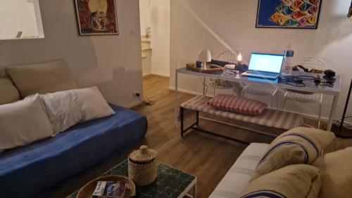 a living room with a couch and a table with a laptop at House 100 meters from the beach in Marina di Ragusa