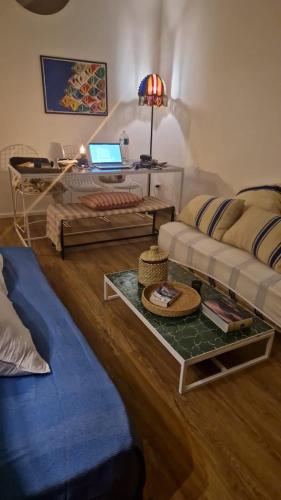 a living room with a couch and a table with a laptop at House 100 meters from the beach in Marina di Ragusa