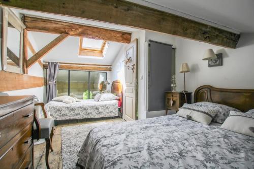 a bedroom with two beds and a window at Gîtes de Gueynard in Gauriaguet