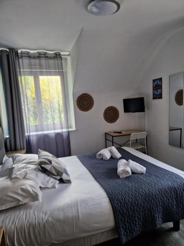 a bedroom with a large bed with towels on it at Hotel La Voilerie Cancale bord de mer in Cancale