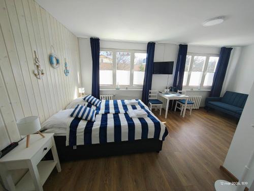 a bedroom with a bed with blue and white striped sheets at Gryfhaus - Pokój Bosmański, kameralny, 22 m2, parking, Wi-Fi, blisko morza, wysoka ocena 9,9 in Międzyzdroje
