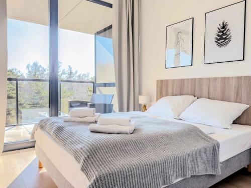 a bedroom with a bed with two towels on it at Apartamenty Shellter Rogowo - ALL DAY HOLIDAY in Rogowo