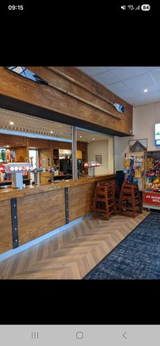 a restaurant with a counter and stools in a room at Highfield Grange Holiday Park in Little Clacton