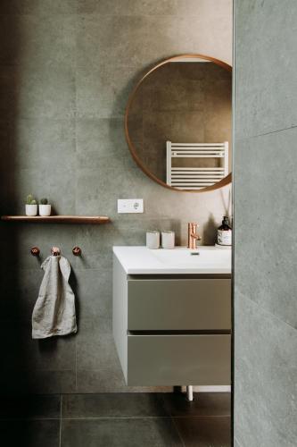 a bathroom with a white sink and a mirror at Bohemian Wellness met hottub & sauna in Ewijk
