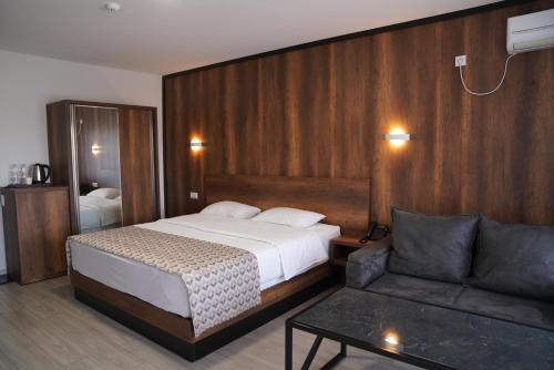 a hotel room with a bed and a couch at Aventus Hotel in Akhaltsikhe