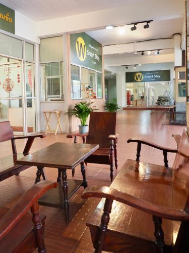 a restaurant with wooden tables and chairs in a store at W Smart Stay TRANG in Trang