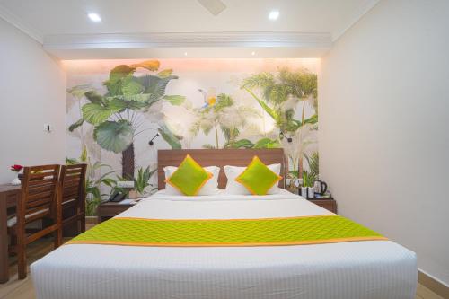 a bedroom with a large bed with a tropical mural at Hotel Apsara in Kizhake Chālakudi
