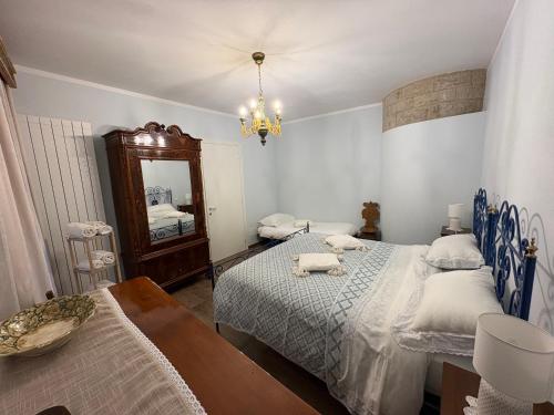 a bedroom with two beds and a mirror at Casa Vacanze Il Borgo in Gubbio