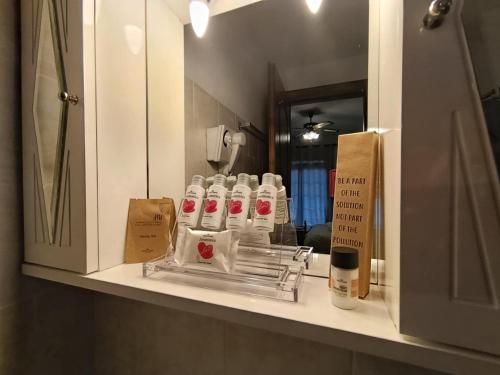 a bathroom counter with a mirror and a shelf with bottles of soap at To Kallion in Karpenisi