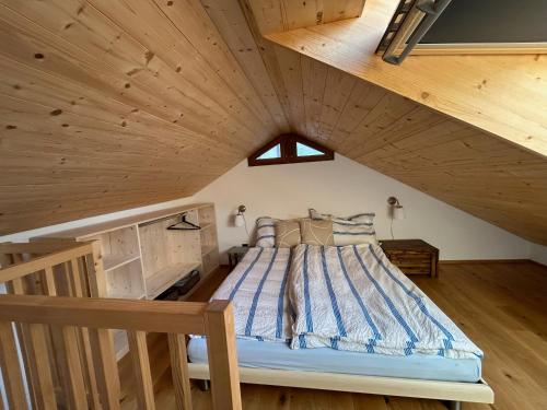 a bedroom with a bed in a wooden attic at Casa Majagatt Holiday Home in Roveredo