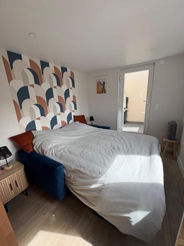 a bedroom with a large bed with a geometric headboard at Studio cosy avec balcon in Dunkerque