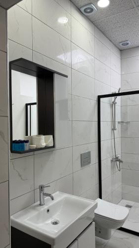 a bathroom with a sink and a mirror and a toilet at Necip Bey Elegant Villa in Antalya