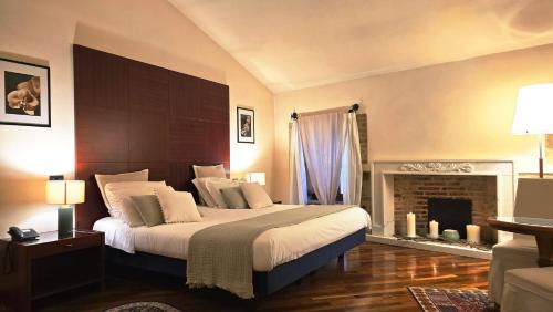 ein Schlafzimmer mit einem großen Bett und einem Kamin in der Unterkunft Relais La Corte di Bettona in Bettona
