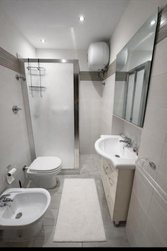 a bathroom with a toilet and a sink and a shower at Casa vacanza da Paola in Trapani