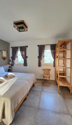 a bedroom with a bed and a chair and windows at Feli Eski Datca Adult Only in Datca