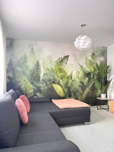 a living room with a mural of plants on the wall at Deluxe Apartment Ella in Backnang