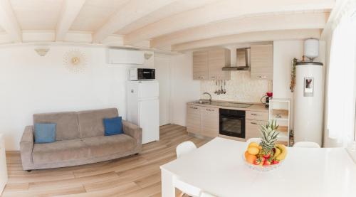 a kitchen and living room with a couch and a table at Villa AMARE in Caorle