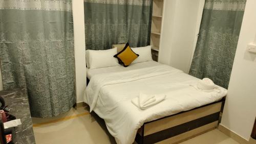 a small room with a small bed with two white towels at RKS Homestay Anex in Shillong