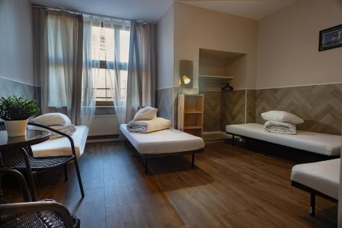 a room with two beds and a table and a window at Rynek 7 in Katowice