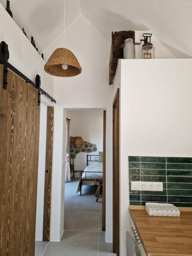 a room with a hallway with a bedroom with a bed at Bagolyvölgy Tulkó Ház in Balatonhenye