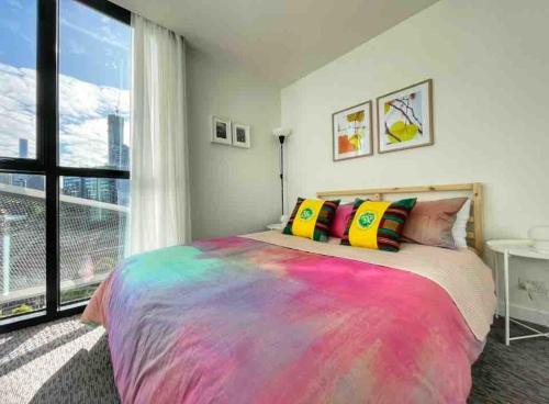 a bedroom with a large bed with colorful pillows at Harbour Haven Sleep 7 Free Parking Free Tram to CBD in Melbourne