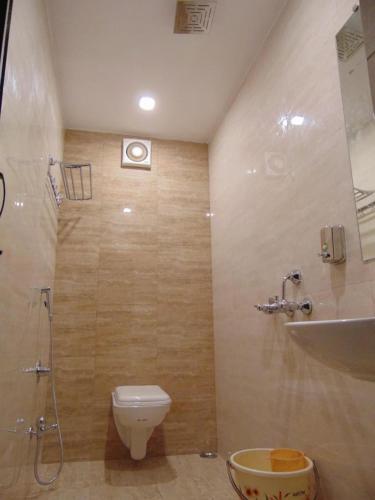 a bathroom with a toilet and a shower and a sink at Hotel Meghdoot in Bhadohī