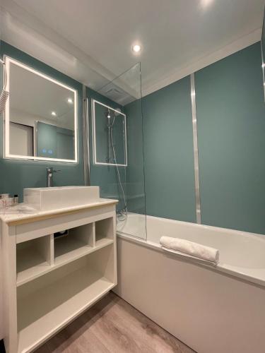 a bathroom with a tub and a sink and a shower at LE M HOTEL & SPA HONFLEUR in Honfleur