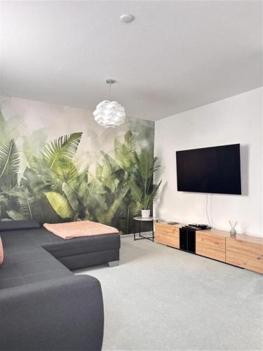 a living room with a couch and a flat screen tv at Deluxe Apartment Ella in Backnang