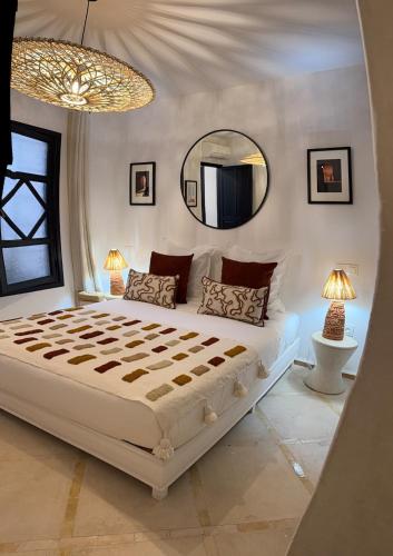a bedroom with a large bed and a large mirror at Riad Al Jadd - 5 Bedrooms - Pool - Breakfast in Marrakesh
