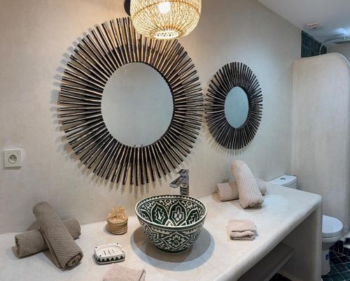 a bathroom with a sink and two mirrors on the wall at Riad Al Jadd - 5 Bedrooms - Pool - Breakfast in Marrakesh