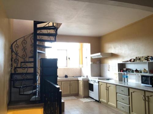 a kitchen with a spiral staircase in a kitchen at Escale Gris Gris, breathtaking views and location! in Souillac