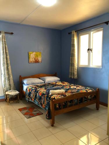 a bedroom with a bed in a blue wall at Escale Gris Gris, breathtaking views and location! in Souillac