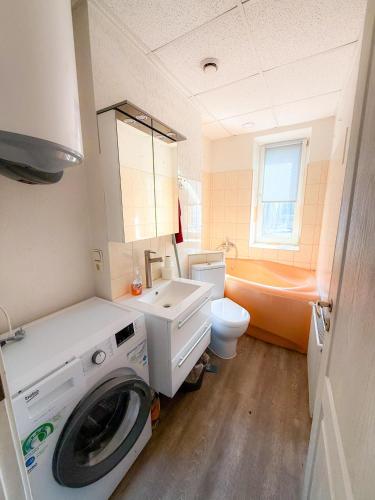 a bathroom with a washing machine and a toilet at Mājīgs dzīvoklis Aizputē in Aizpute
