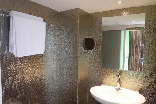 een badkamer met een wastafel en een spiegel bij The Montana Lodge-Sathorn in Bangkok