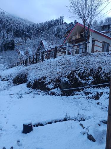 a house on a hill with snow on the ground at Moksh Jibhi Retreat in Jibhi