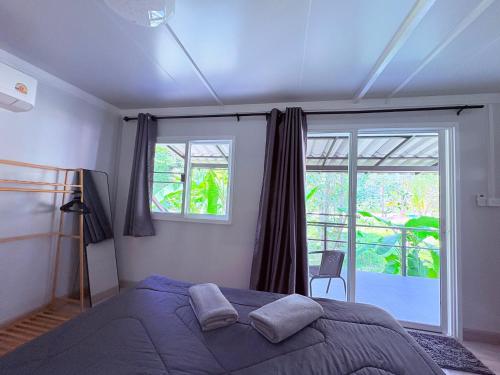 a bedroom with a bed and a large window at Moon Jungle Bungalows in Ban Madua Wan
