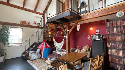 a living room with a table and a staircase at B&BHOUSE FAM in Ichinomiya