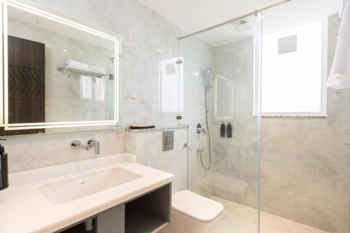 a bathroom with a sink and a glass shower at Hotel HiStays, Dehradun in Dehradun