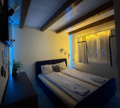a bedroom with a bed and a window with blue lights at Cabana Moldovan Baisoara cu piscina interioara, ciubar, spa in Lunca Largă