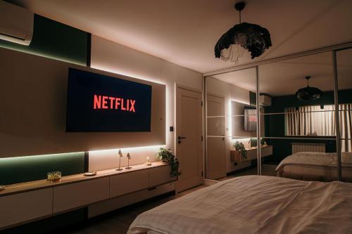 a bedroom with a netflix sign on the wall at Sage Studio in Drobeta-Turnu Severin