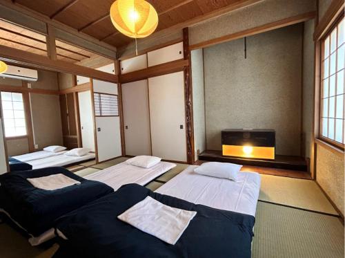 a room with three beds and a tv in it at tot-an 14mins from Toyama station #HH7 in Toyama Station