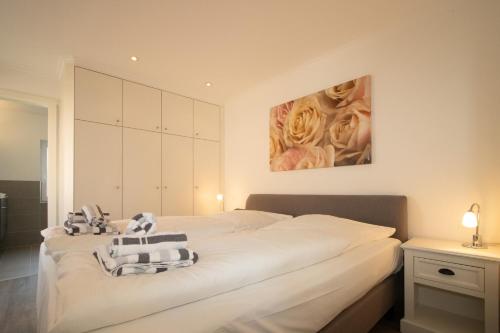 a bedroom with a large white bed with towels at Haus Roseneck App.1 in Hörnum