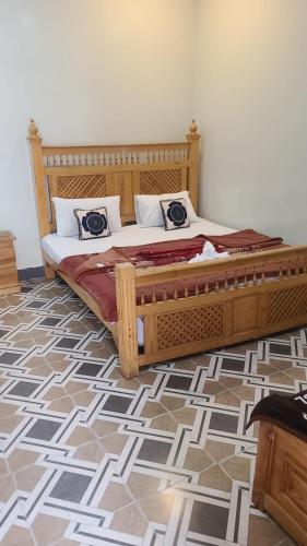 a bed with a wooden frame in a room at Balakot View Hotel in Bauli