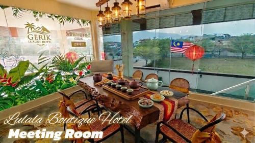 a dining room with a table and chairs and a meeting room at Lulala Boutique Hotel in Gerik