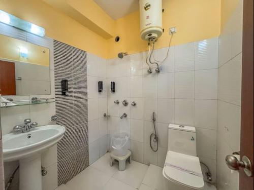 a white bathroom with a sink and a toilet at Rare Himalayas De Regency Pelling in Pelling