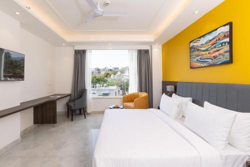 a hotel room with a bed and a desk at Hotel HiStays, Dehradun in Dehradun