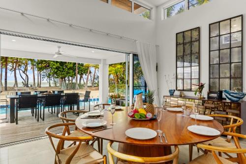 a dining room with a table and chairs at Tenterfield Beachfront Luxury 4 Bedroom Holiday Home in Oak Beach